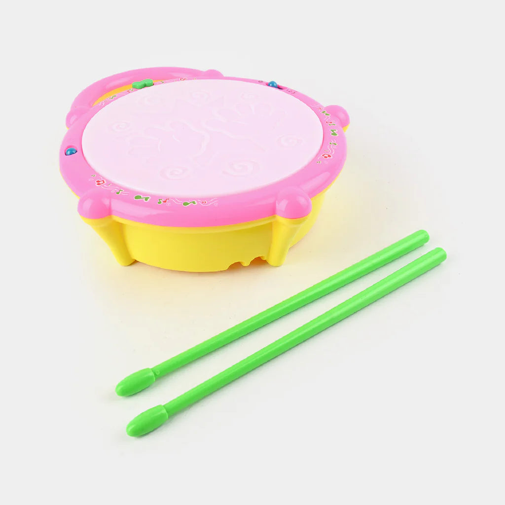 Children's drum with pink top and yellow bottom, accompanied by two green drumsticks on a white background.