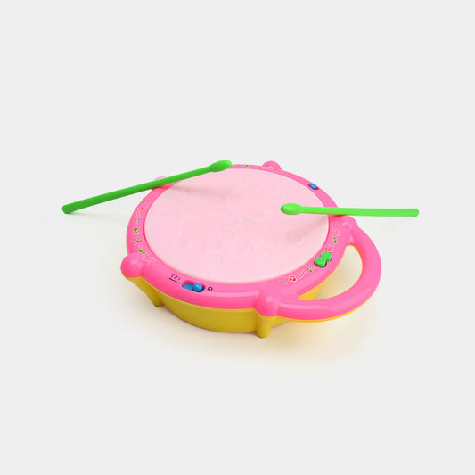 Pink toy drum with two green drumsticks on a white background